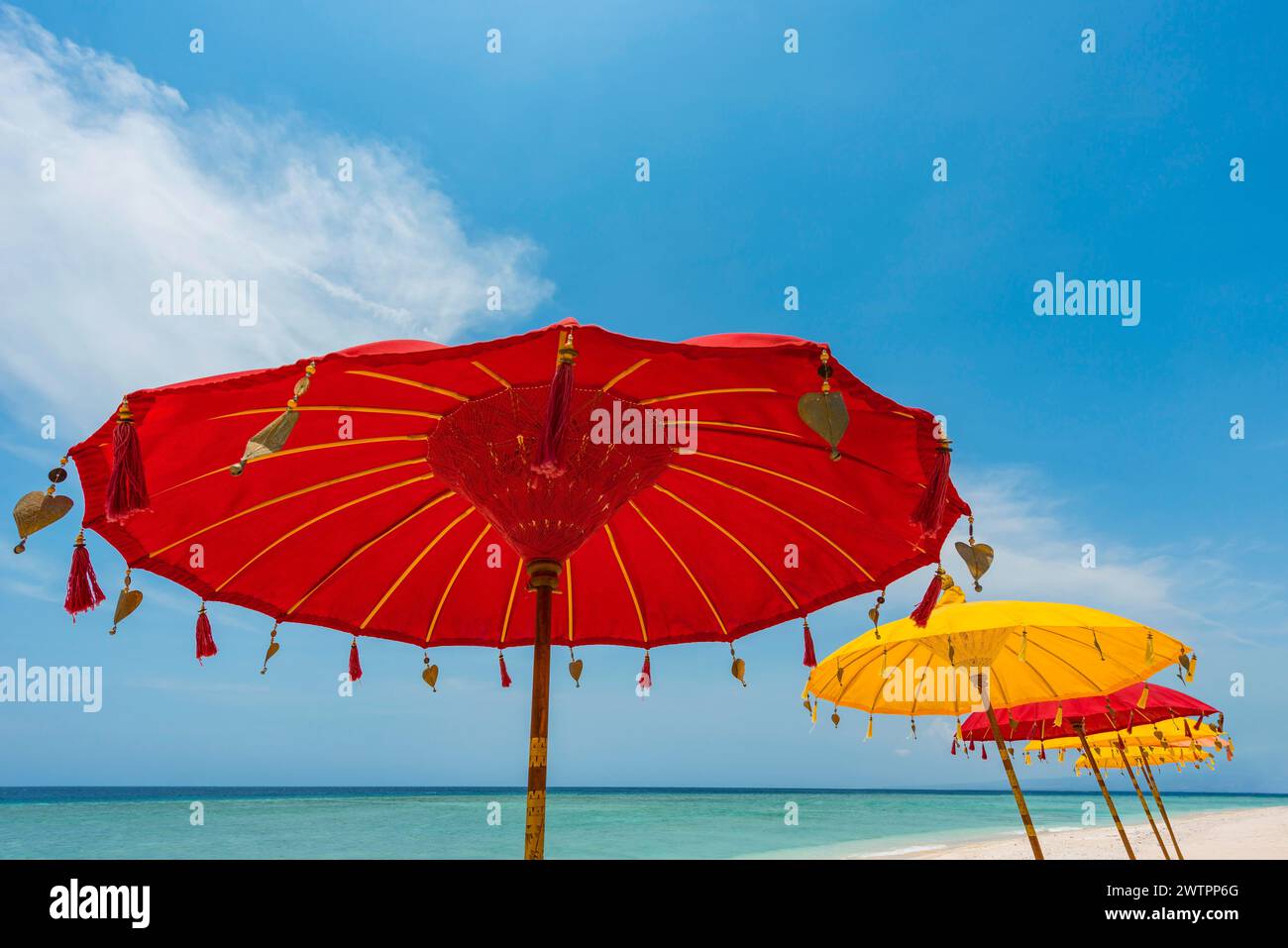 Parasol traditionnel de temple balinais comme parasol, hindouisme, symbole, vacances à la plage, protection, protection solaire, balinais, culture, rouge, jaune, dim Banque D'Images