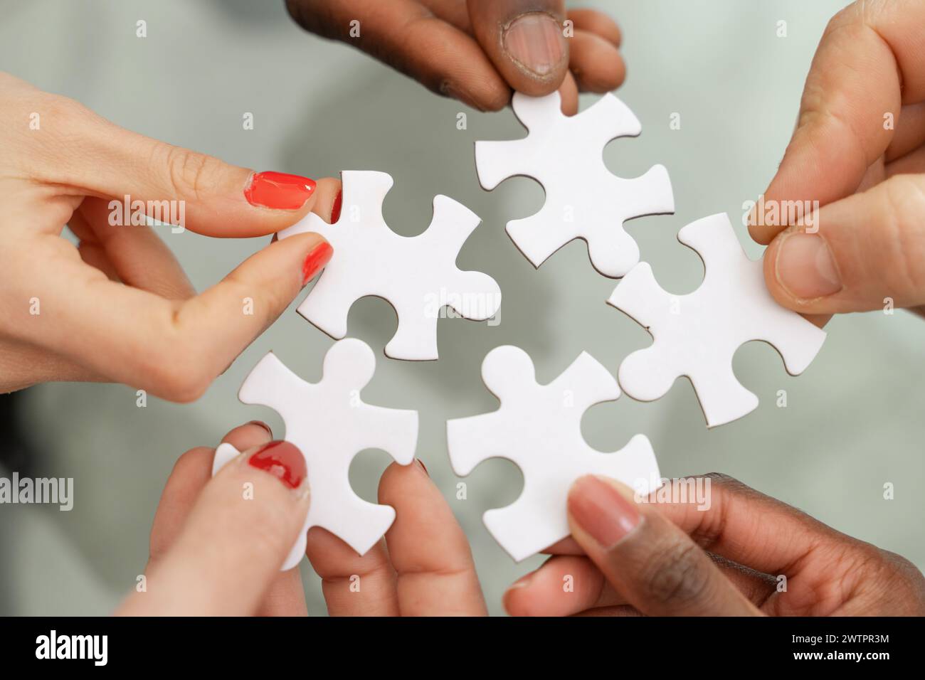 Mains multi-ethniques - assemblage puzzle - symbole du travail d'équipe et des solutions, de la collaboration et de la résolution de problèmes - trouver un concept de solution commune Banque D'Images