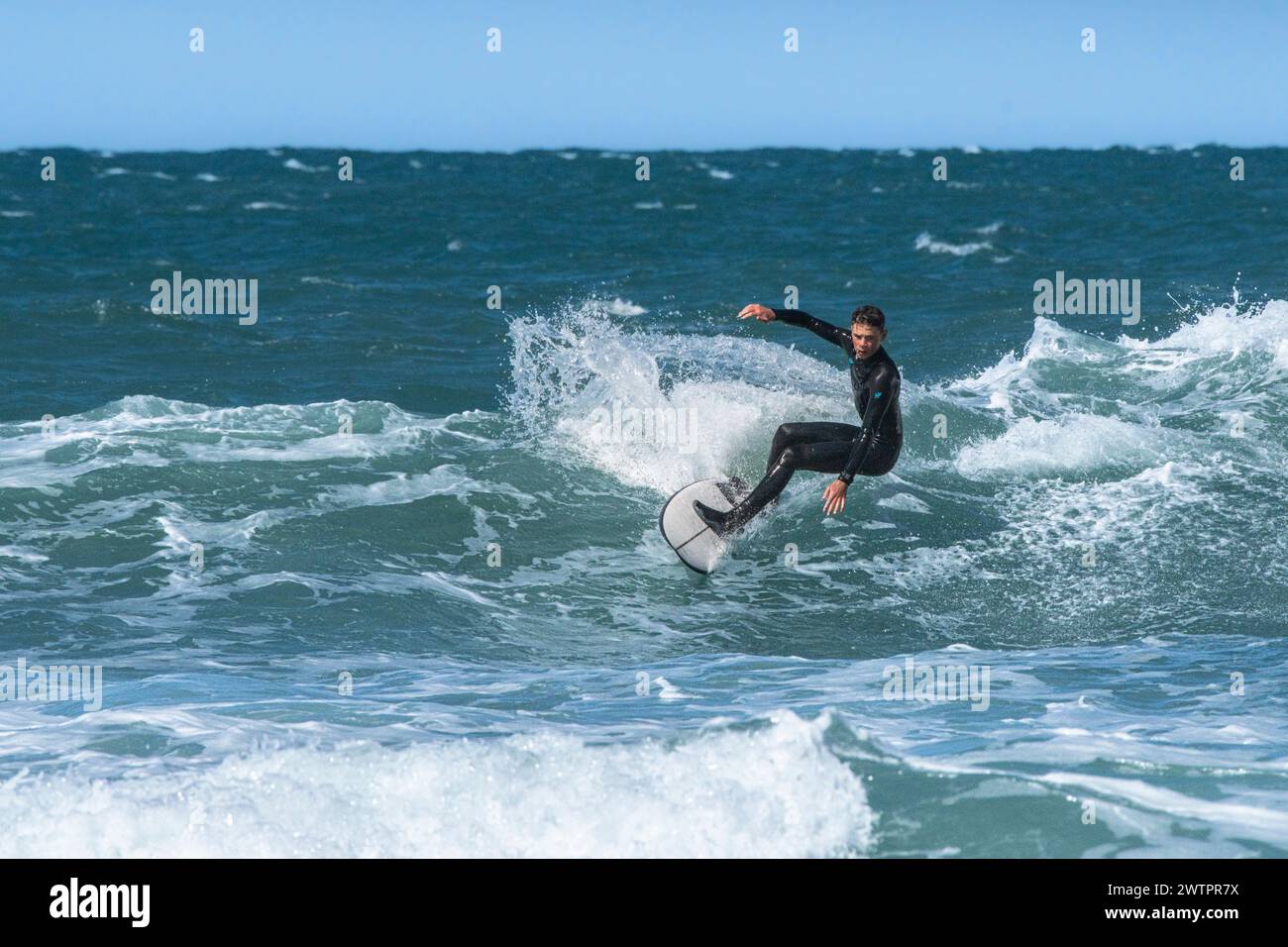 Un surfeur mâle qui fait une vague à Fistral, à Newquay, en Cornouailles, au Royaume-Uni. Banque D'Images