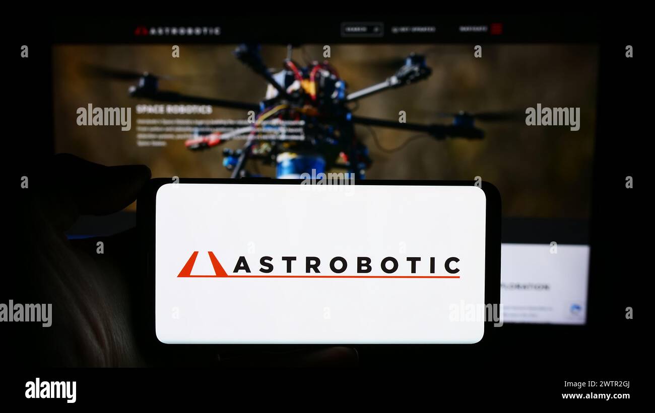 Personne tenant le téléphone portable avec le logo de la société américaine de robotique spatiale Astrobotic Technology Inc devant la page Web de l'entreprise. Concentrez-vous sur l'affichage du téléphone. Banque D'Images