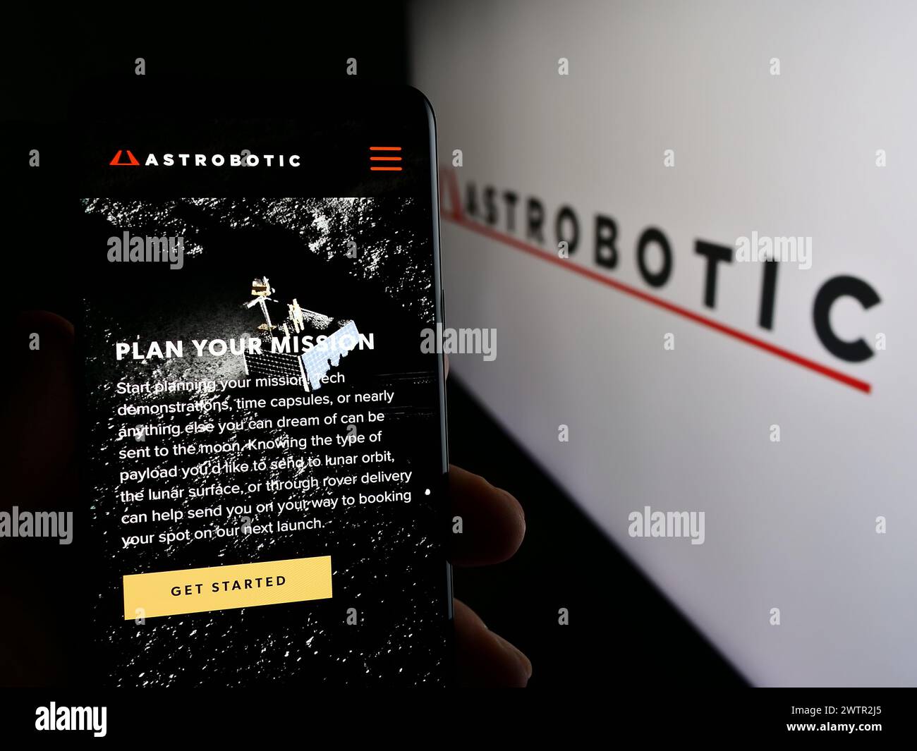 Personne tenant le téléphone portable avec la page Web de la société américaine de robotique spatiale Astrobotic Technology Inc devant le logo. Concentrez-vous sur le centre de l'écran du téléphone. Banque D'Images
