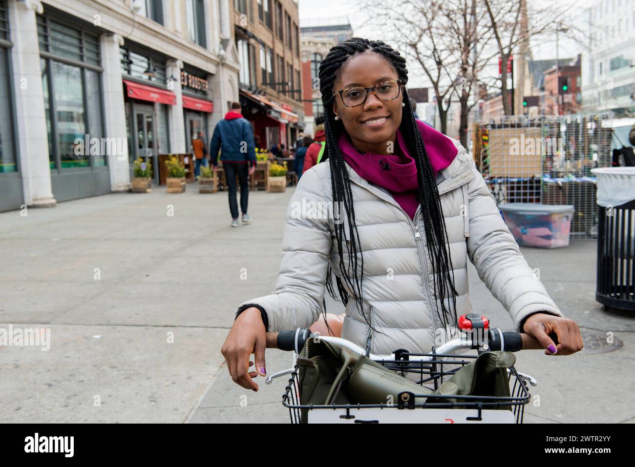 Femme en tournée New York City, USA. Attrayante afro-américaine, femme adulte donnant une visite guidée en vélo aux touristes et aux visiteurs à travers Harlem, Manhattan. MRYES New York City The Streets of Harlem New York États-Unis Copyright : xGuidoxKoppesx Banque D'Images