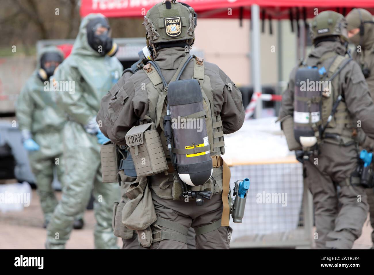 Angehörige des Spezialeinsatzkommandos der bayerischen Polizei SEK begeben sich in Schutzkleidung zu einer von der Feuerwehr eingerichteten Station zur Dekontaminierung von Personen, sog. Dékontamination CBRN. Länderübergreifende Großübung der Spezialeinheiten exercice de lutte contre le terrorisme CTE 2024. Sulzbach-Rosenberg Bayern Deutschland *** les membres du commandement des opérations spéciales de la police bavaroise en vêtements de protection se rendent à un poste mis en place par les pompiers pour décontaminer les personnes, ce qu'on appelle la décontamination CBRN exercice transnational majeur des unités spéciales Counter Terr Banque D'Images