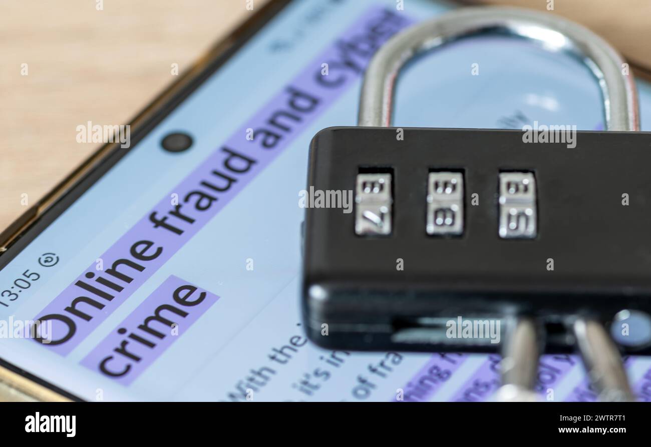 Un concept de sécurité contre la fraude en ligne et la cybercriminalité avec un téléphone intelligent, un cadenas à combinaison et les mots fraude en ligne et cybercriminalité Banque D'Images