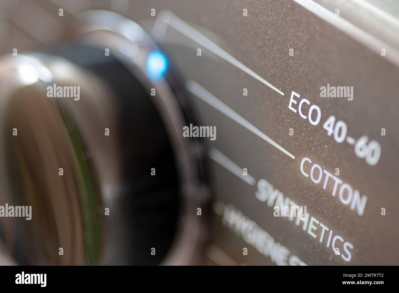 Un concept écologique et économe en énergie avec un lave-linge réglé sur lavage éco. Banque D'Images