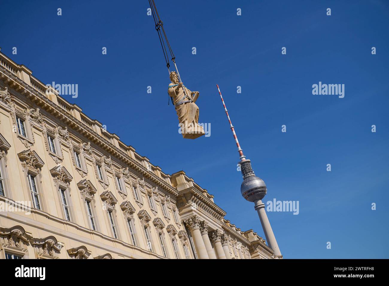 Auf dem Dach des Berliner Humboldt forums stehen seit Dienstag, 19.03.2024, weitere Balustradenskulpturen. Insgesamt sollten acht, jeweils drei Tonnen schwere Propheten-Figuren mit einem Spezialkran aufs Dach gehoben und an der Kuppel-balustrade montiert werden. Bis Dienstagmittag gruesste der Prophet Jeremias vom Dach, wie ein Sprecher der Stiftung Humboldt Forum auf Anfrage mitteilte Foto vom 19.03.2024 : Die figure des Propheten Jeremias wird mit einem Schwerlastkran zur Kuppel gehoben. Die Sandsteinfiguren sind einschliesslich Grundplatte jeweils 3,3 mètres brut, drei Tonnen schwer und haben Banque D'Images