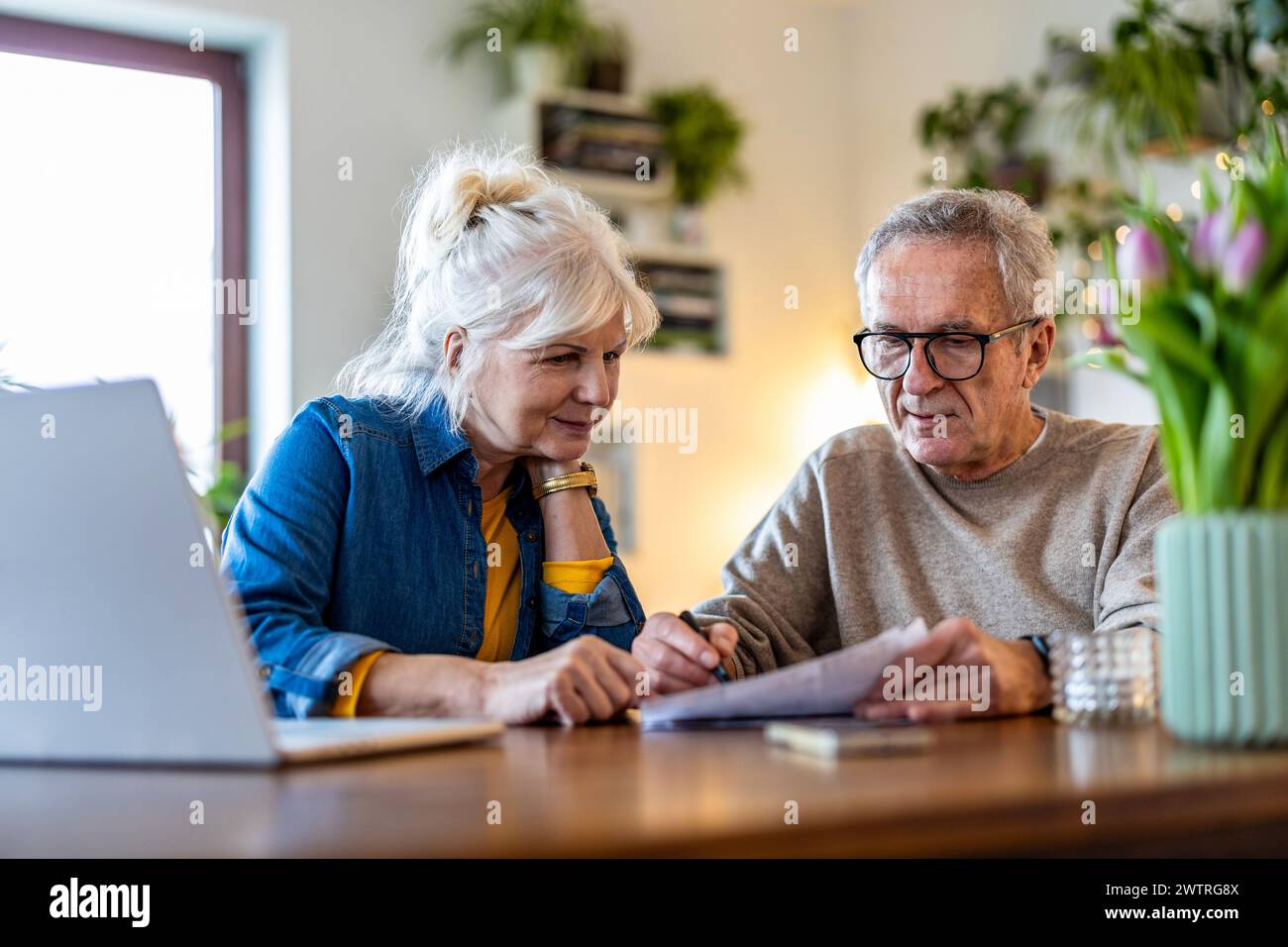 Couple aîné assis à la table discutant des finances de la maison Banque D'Images