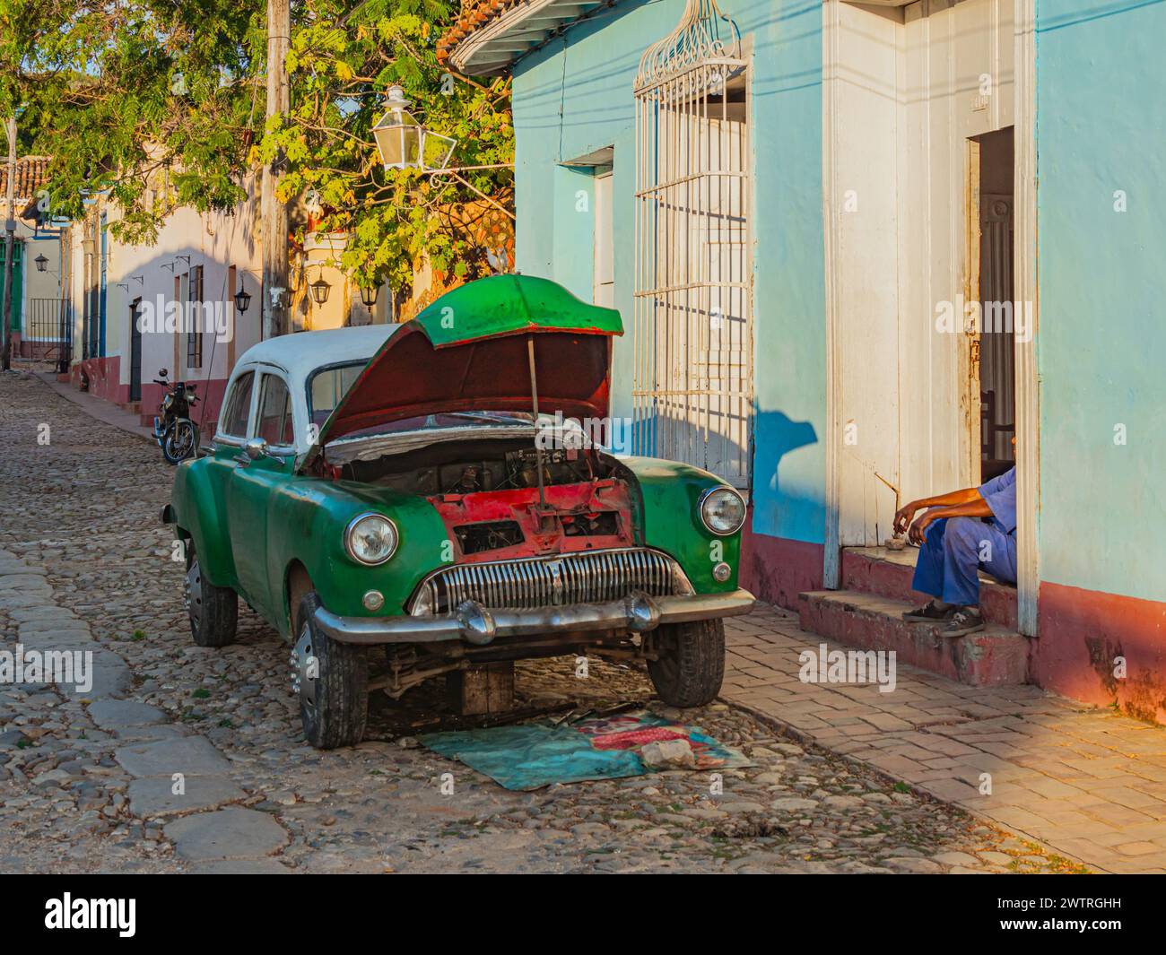 Vintage voiture américaine classique se faire réparer dans la rue. La réparation fonctionne avec le moteur d'une vieille voiture américaine. Vieille voiture américaine en cours de réparation dans une rue de la ville. Sity Life on Cuba, Trinidad Banque D'Images