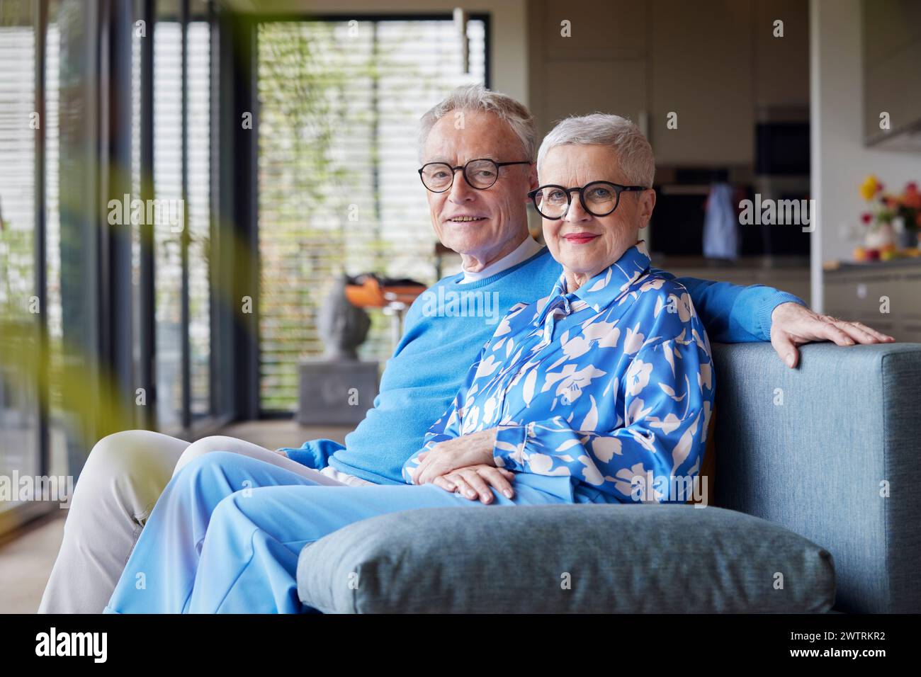 Portrait d'un couple de personnes âgées assis sur un canapé à la maison Banque D'Images