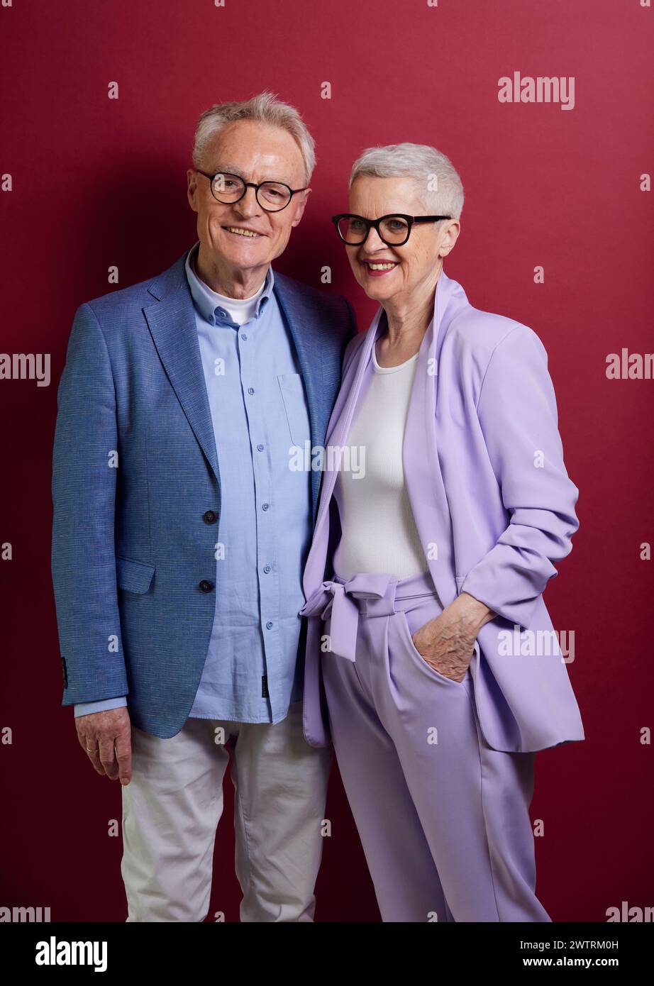 Portrait de couple senior confiant sur fond violet Banque D'Images