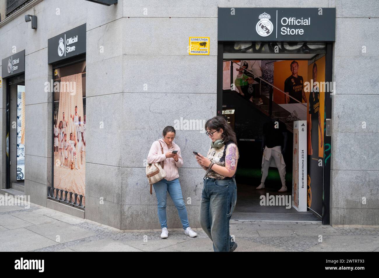 Les femmes sont vues devant le magasin de vêtements de sport officiel de l'équipe de football professionnel espagnole Real Madrid Club et le logo à Madrid. Banque D'Images