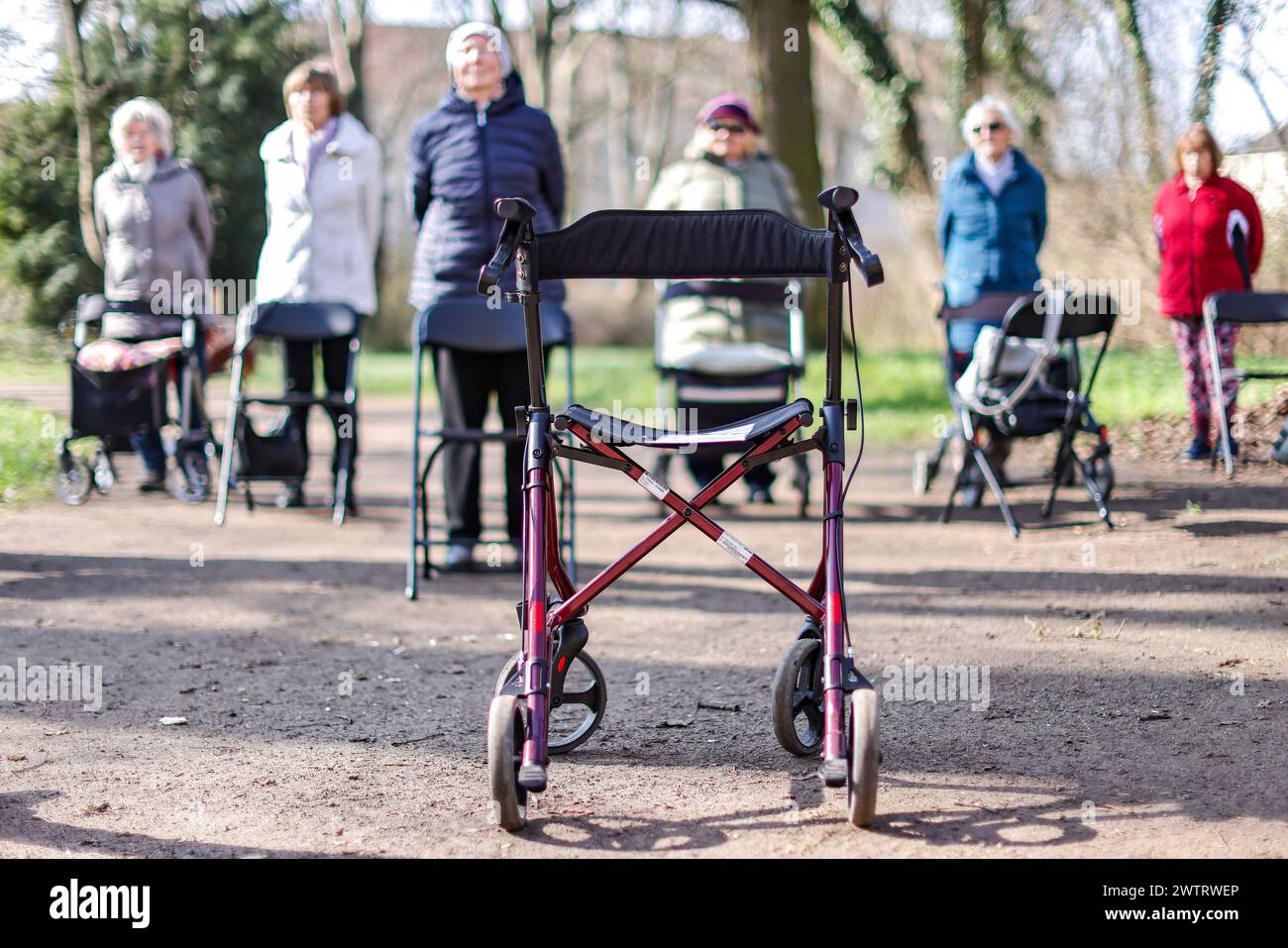 PRODUCTION - 13 mars 2024, Saxe-Anhalt, Köthen : les seniors participent à un cours de yoga rollator pour seniors dans le parc du château de Köthen. Le cours propose des exercices ciblés qui peuvent être effectués sur et hors du rollator. Photo : Jan Woitas/dpa Banque D'Images
