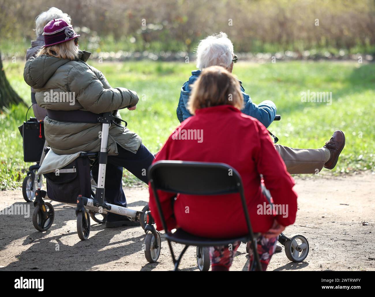 PRODUCTION - 13 mars 2024, Saxe-Anhalt, Köthen : les seniors participent à un cours de yoga rollator pour seniors dans le parc du château de Köthen. Le cours propose des exercices ciblés qui peuvent être effectués sur et hors du rollator. Photo : Jan Woitas/dpa Banque D'Images