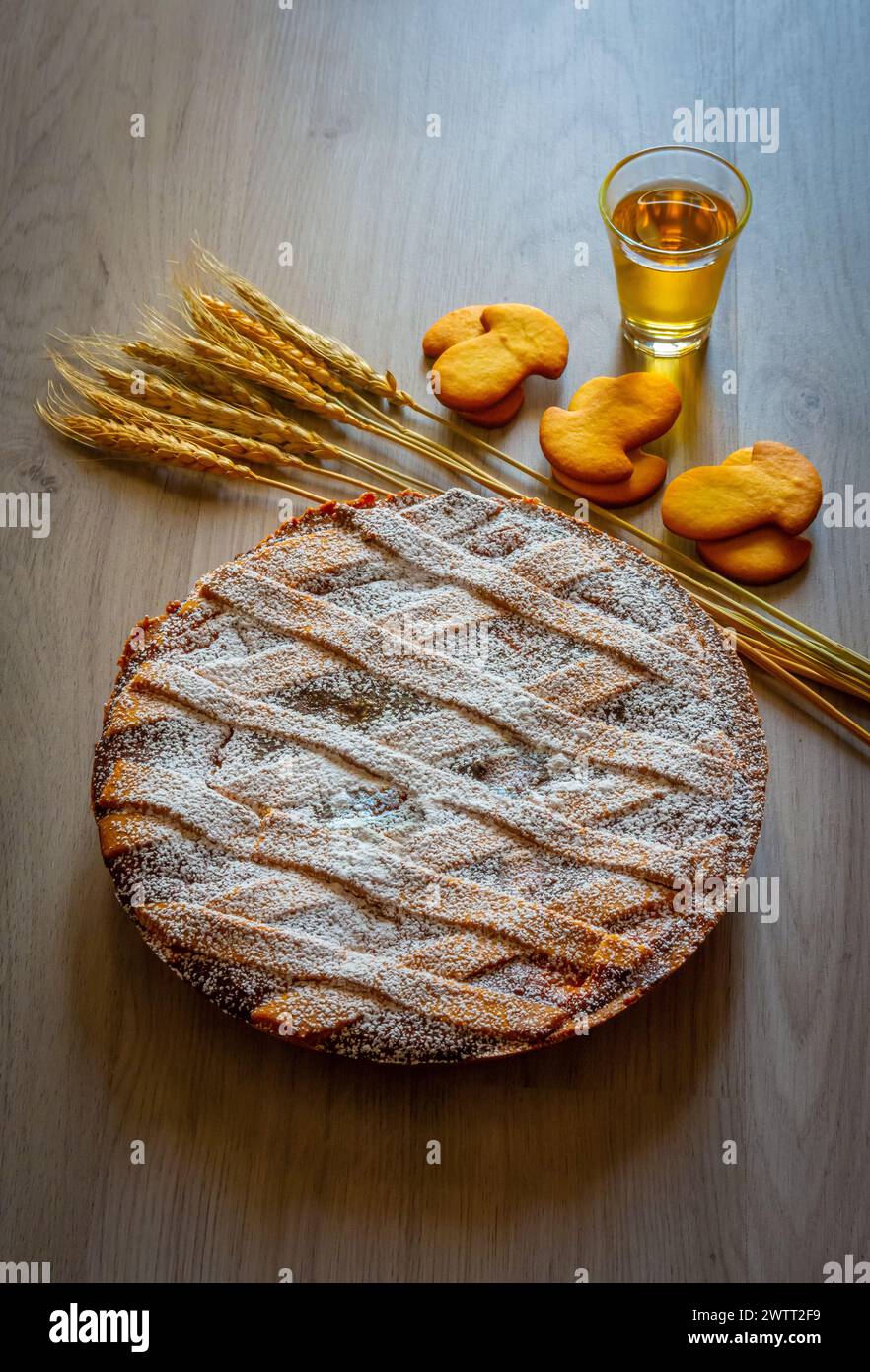 Pastiera crostata napolitaine, gâteau italien typique pour le temps de Pâques exposé avec des épis de blé et des biscuits. Rempli de ricotta et de fruits confits. Banque D'Images