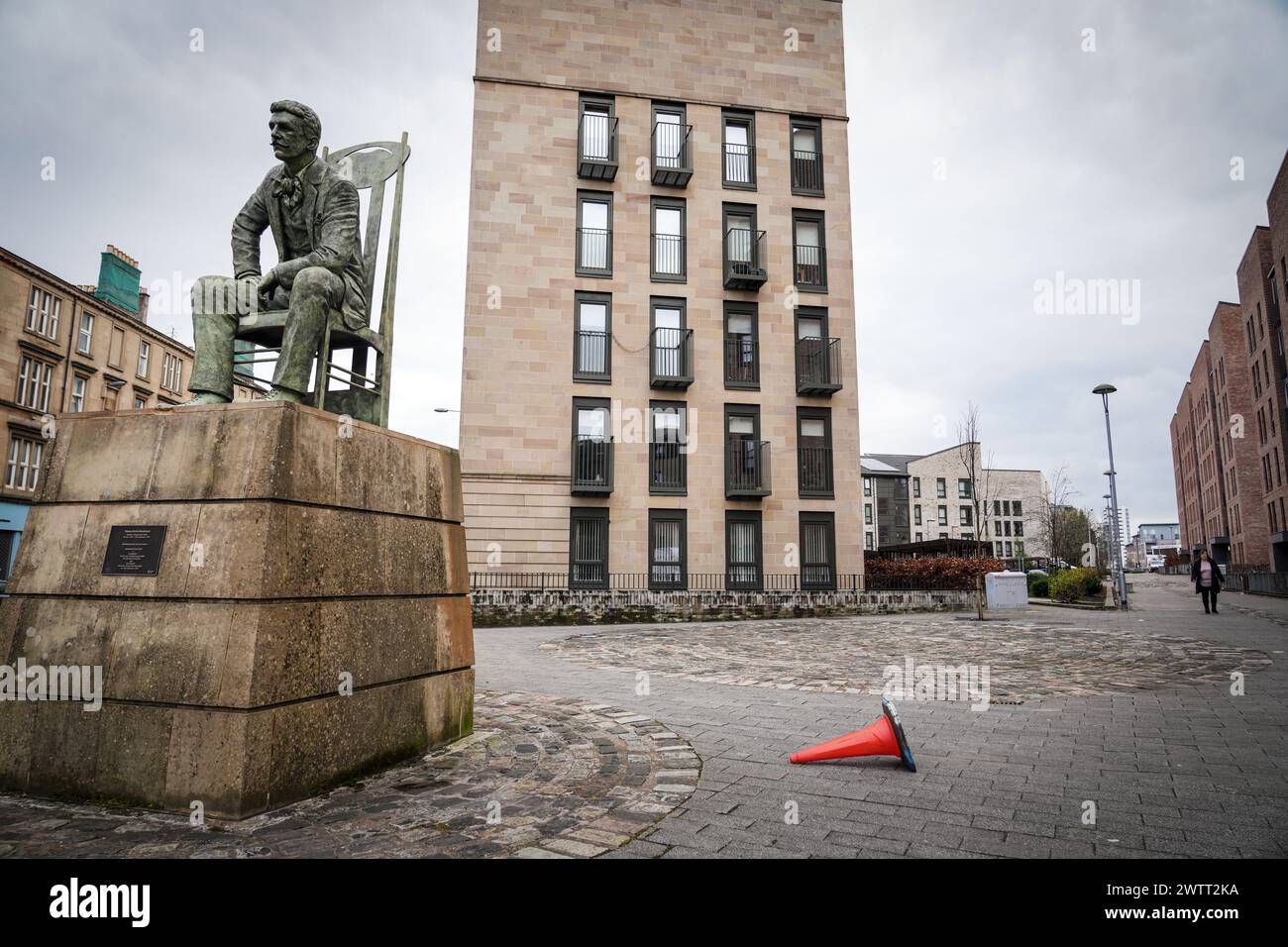Statue de Charles Rennie Mackintosh par le sculpteur Andy Scott, assis sur une chaise Mackintosh à Anderston, Glasgow, dans un immeuble moderne Banque D'Images