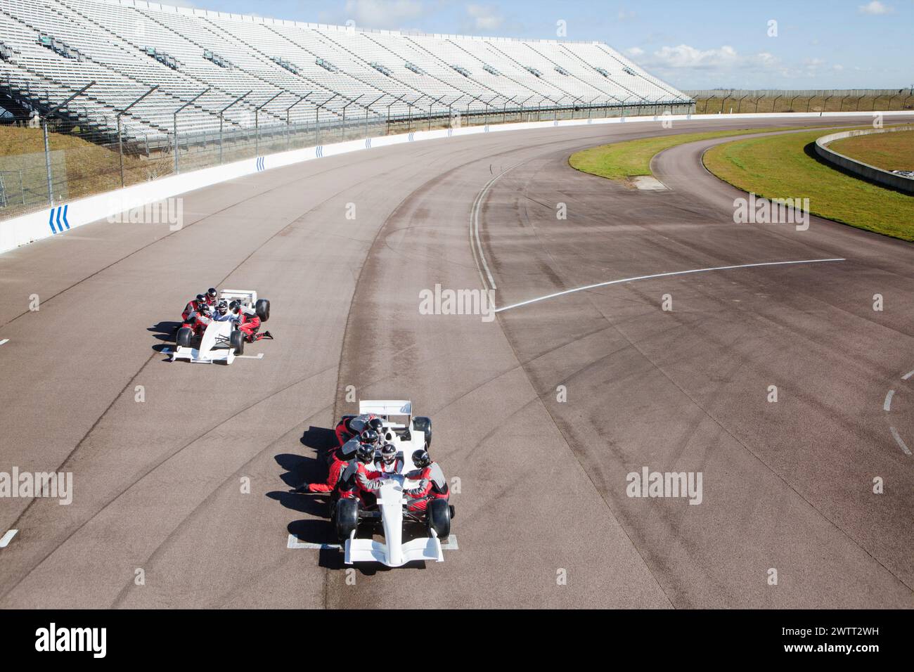 Thrillseeders font la course de gokarts par une journée ensoleillée sur piste. Banque D'Images