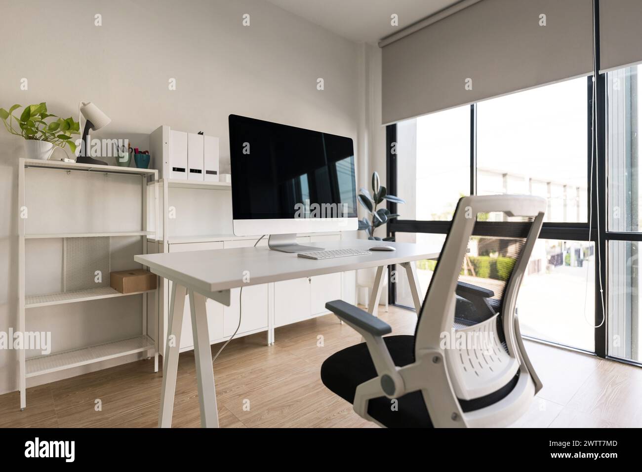 Table blanche et chaise avec écran d'ordinateur et classeur moderne dans l'intérieur blanc du bureau à domicile Banque D'Images
