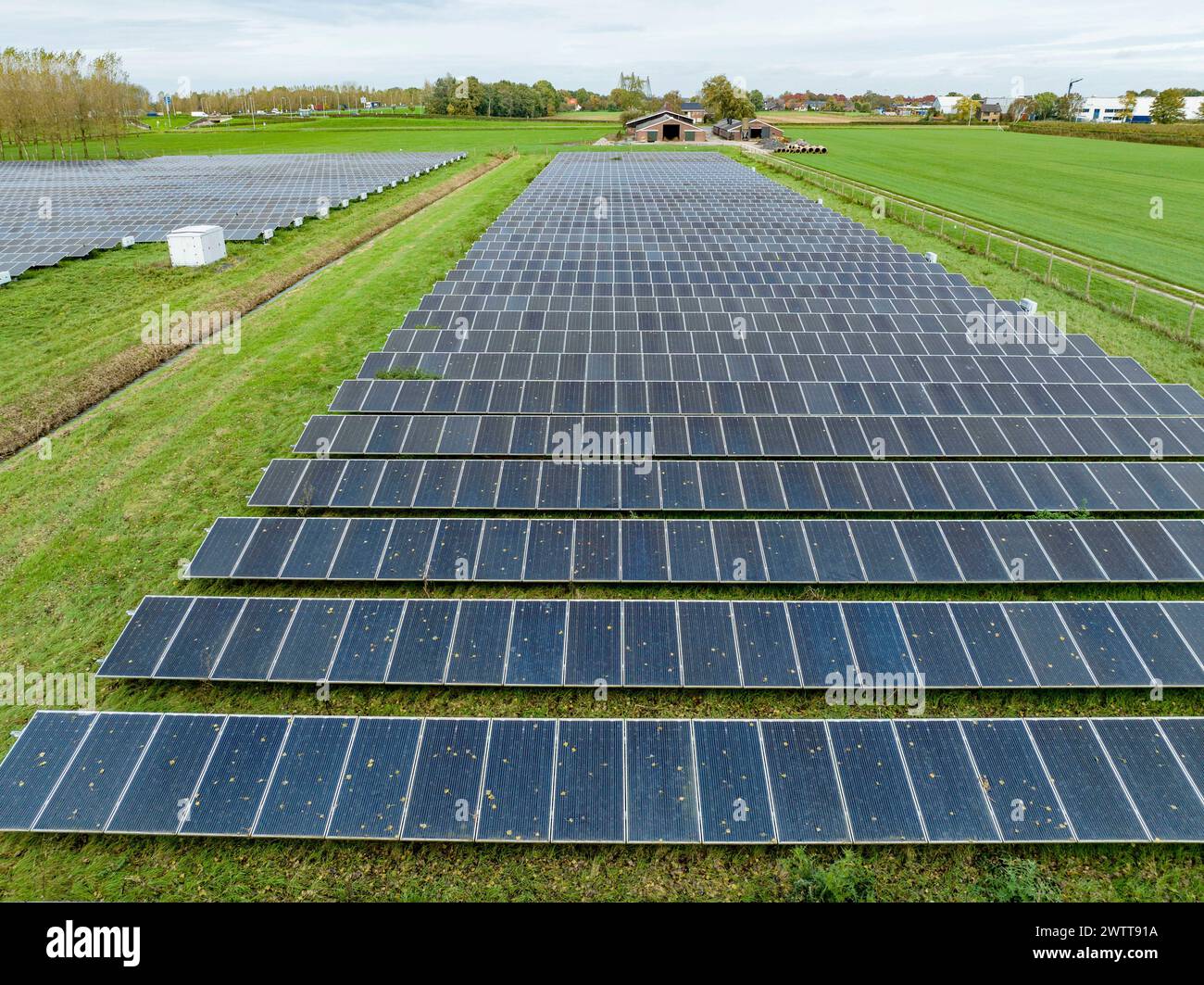 Vaste ferme solaire sous un ciel nuageux Banque D'Images