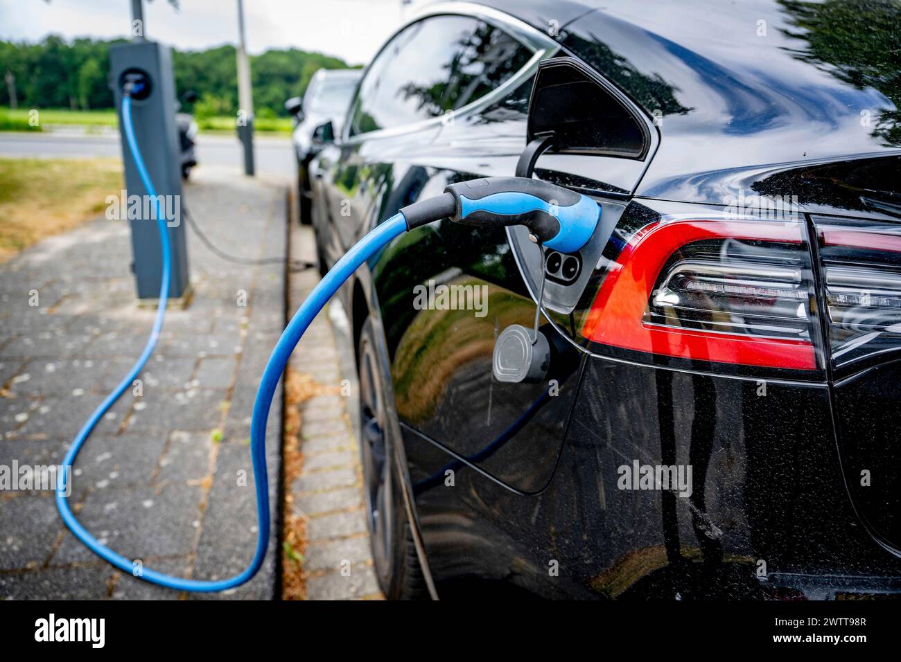 Voiture électrique branchée à une station de charge. Banque D'Images