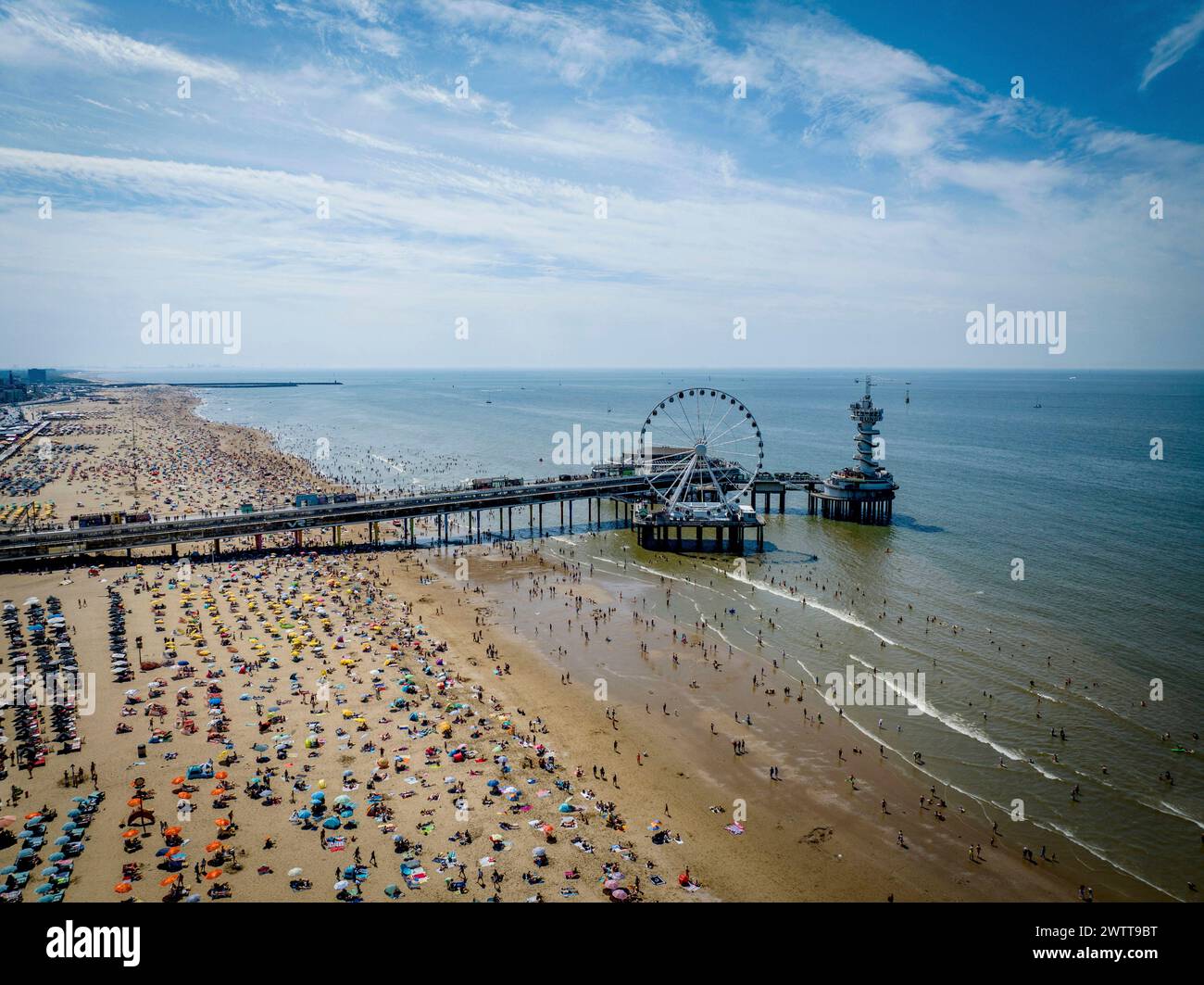 Une journée de plage animée avec une vue panoramique sur une jetée et une grande roue Banque D'Images