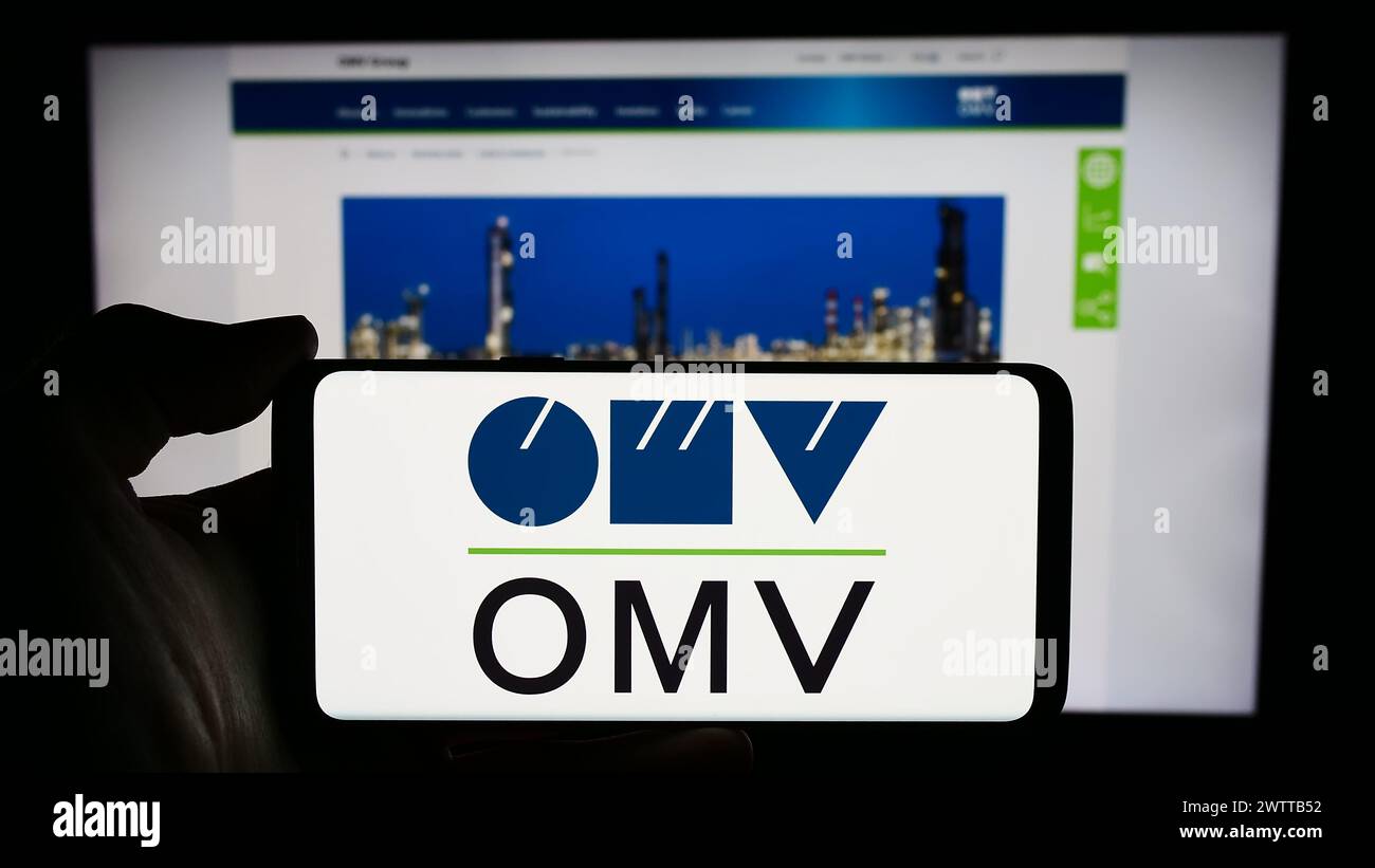 Personne tenant un smartphone avec le logo de la société pétrolière et gazière autrichienne OMV Aktiengesellschaft en face du site Web. Concentrez-vous sur l'affichage du téléphone. Banque D'Images