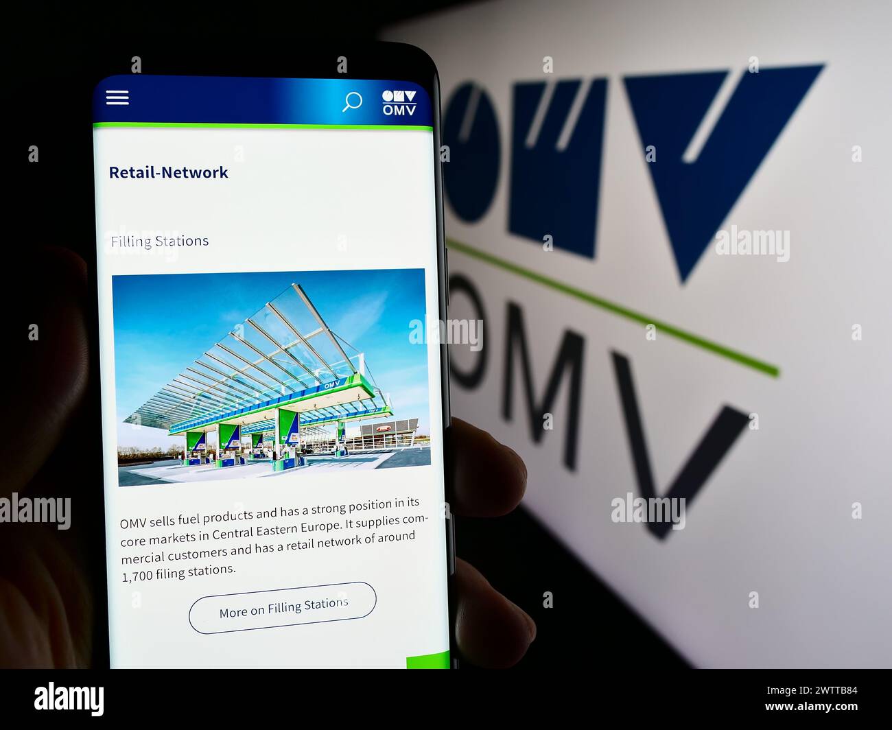 Personne tenant le téléphone portable avec la page Web de la compagnie autrichienne de pétrole et de gaz OMV Aktiengesellschaft avec logo. Concentrez-vous sur le centre de l'écran du téléphone. Banque D'Images