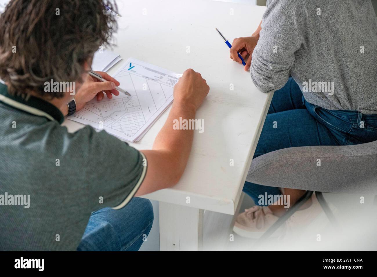 Deux personnes collaborant sur un projet à une table blanche. Banque D'Images