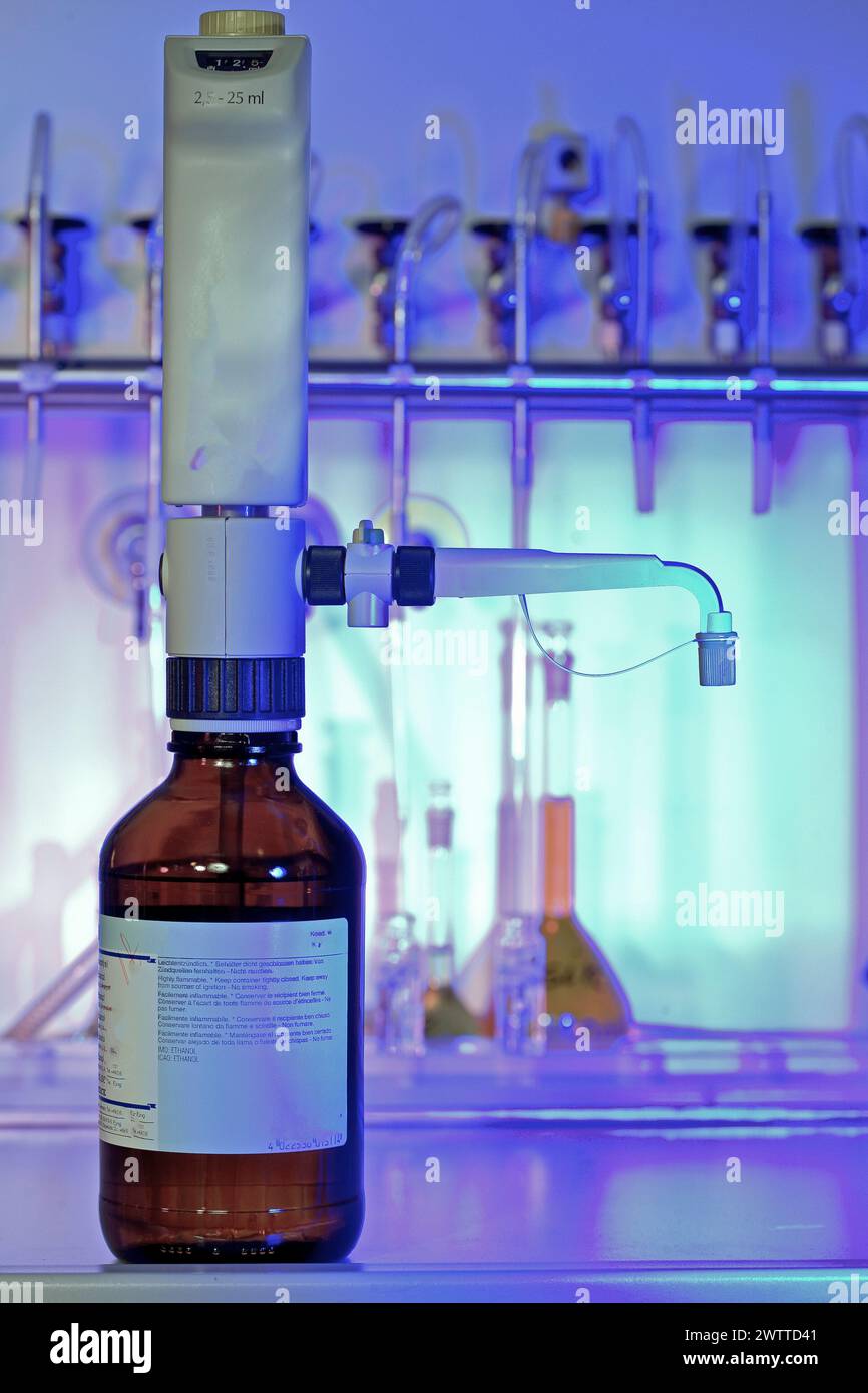 Précision de laboratoire : une burette soigneusement positionnée au-dessus d'un flacon de produit chimique Banque D'Images