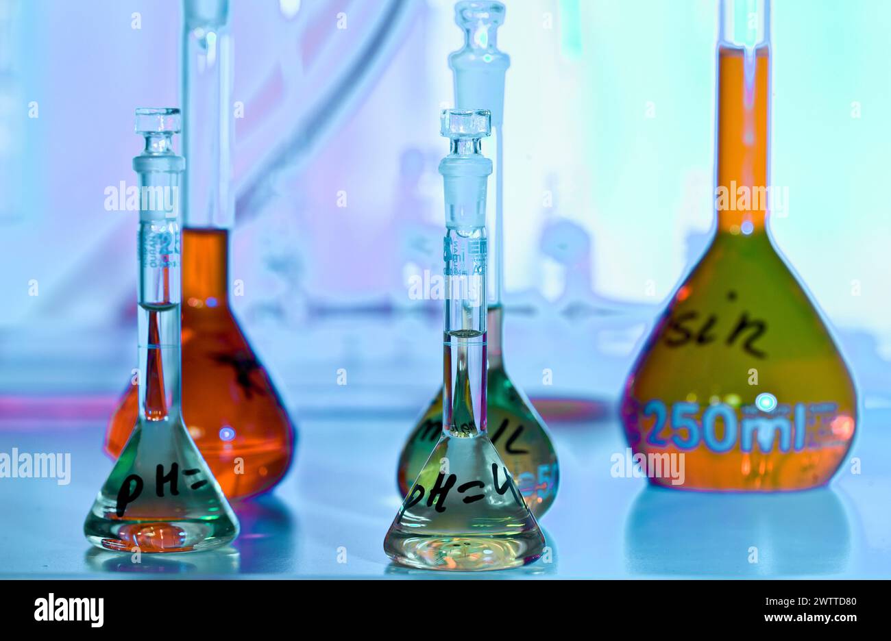 Verrerie de chimie colorée illuminée dans un laboratoire scientifique Banque D'Images