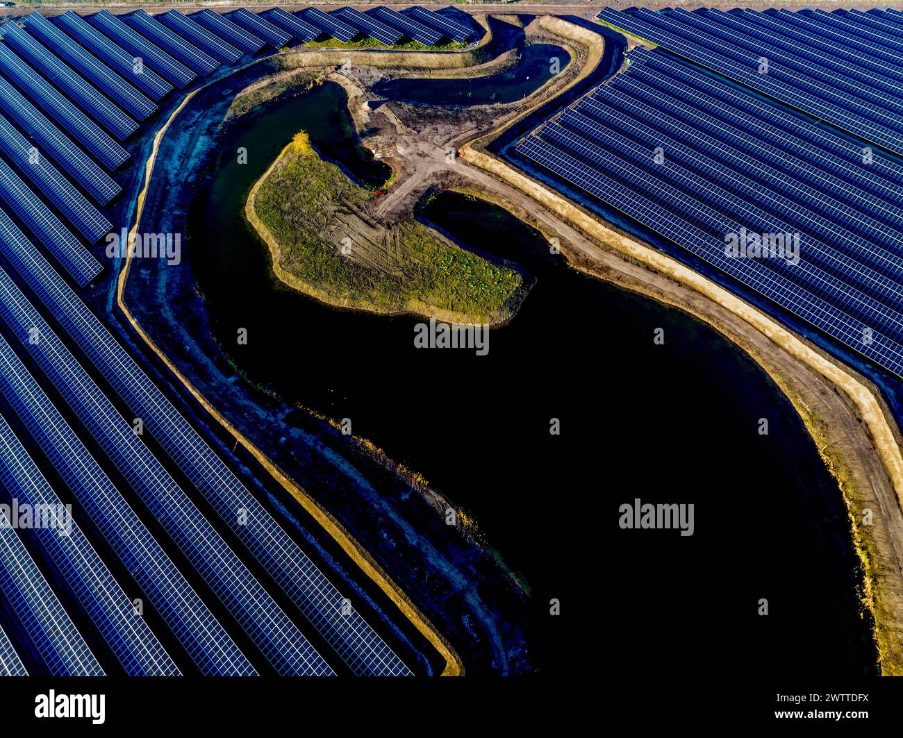 Vue aérienne d'une ferme solaire avec voie navigable sinueuse Banque D'Images