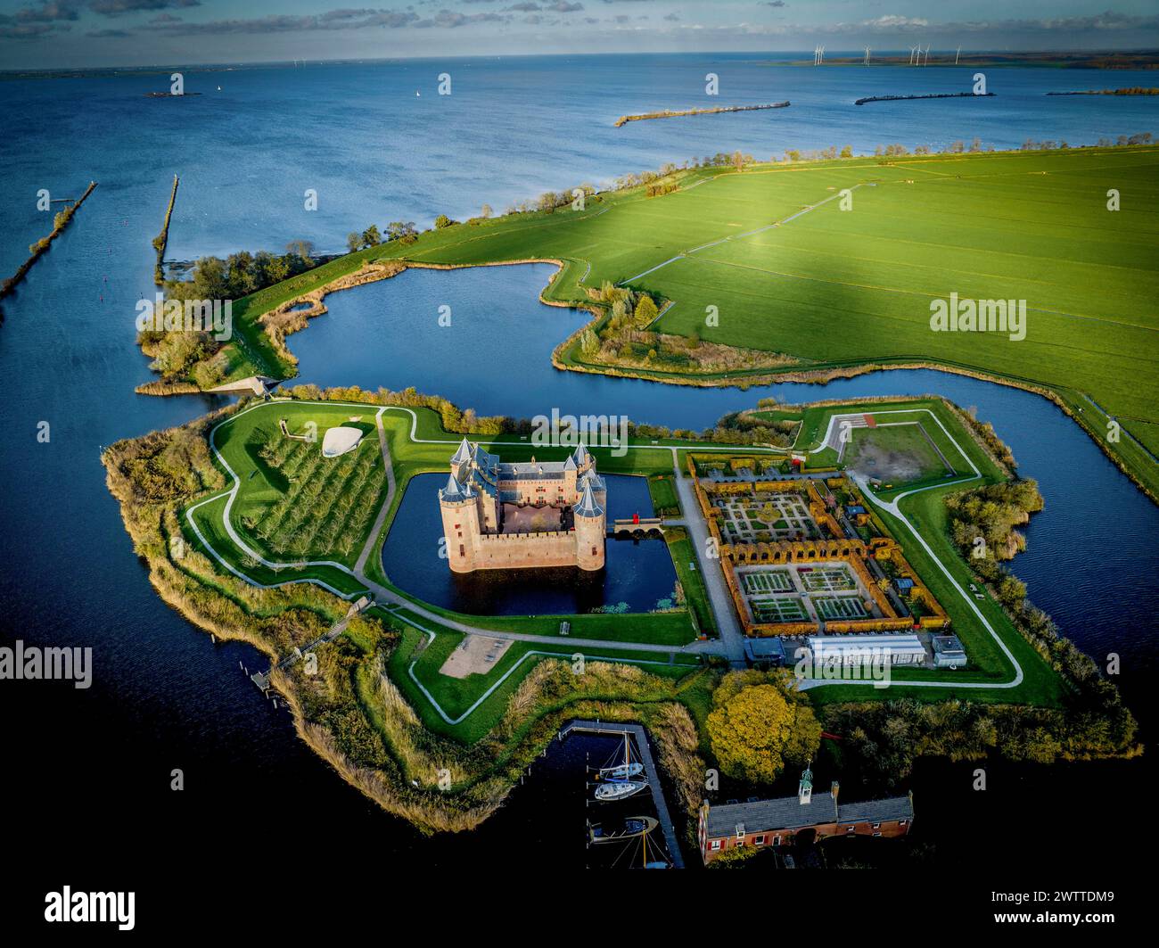 Vue aérienne d'un château historique entouré d'eau et de verdure luxuriante au crépuscule Banque D'Images