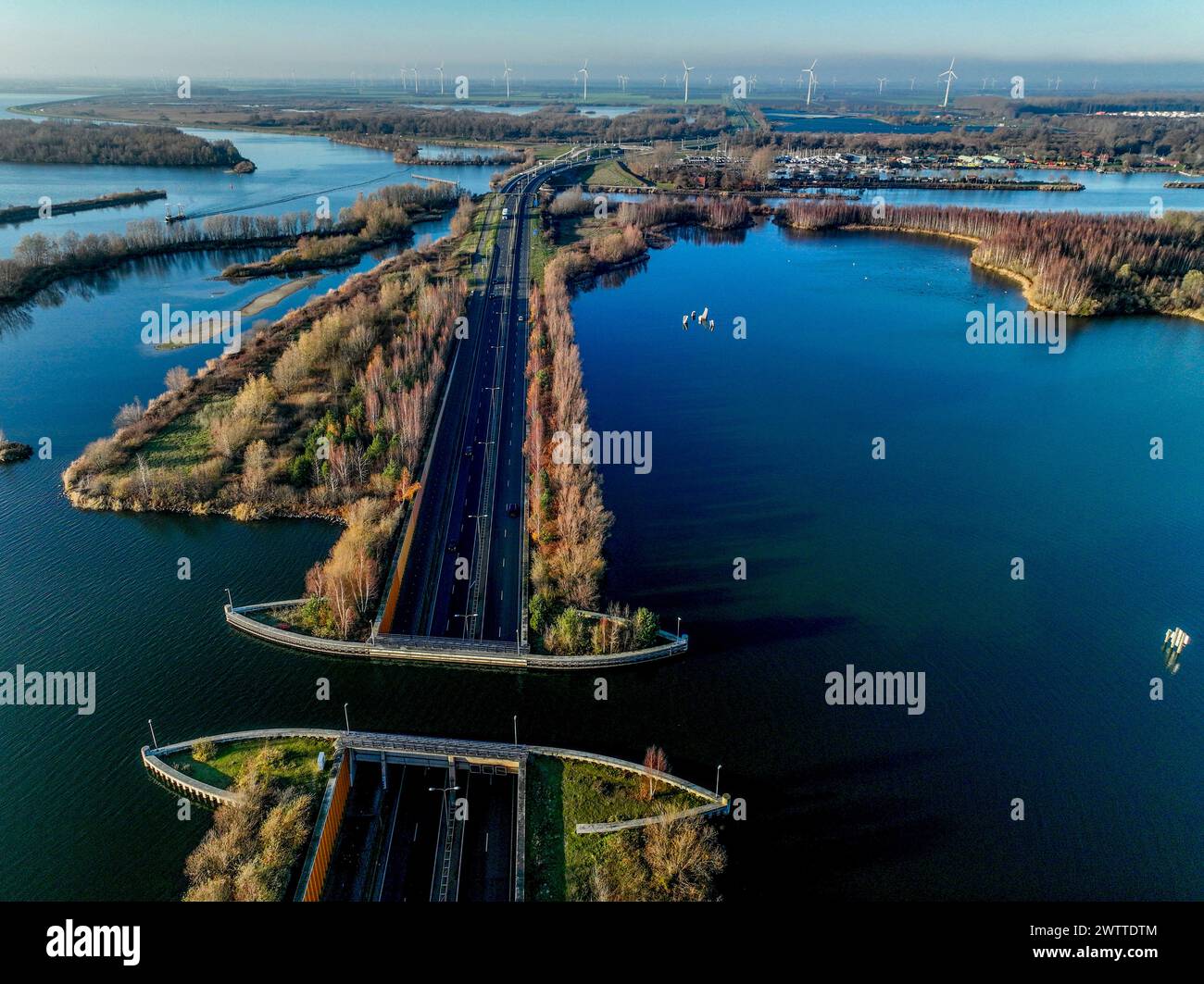 Vue aérienne d'une route sereine prise en sandwich entre des eaux bleues tranquilles sous un ciel clair. Banque D'Images