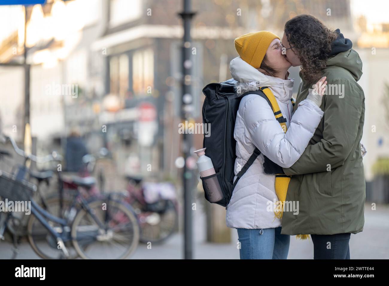 Couple partageant un baiser dans une rue de la ville. Banque D'Images