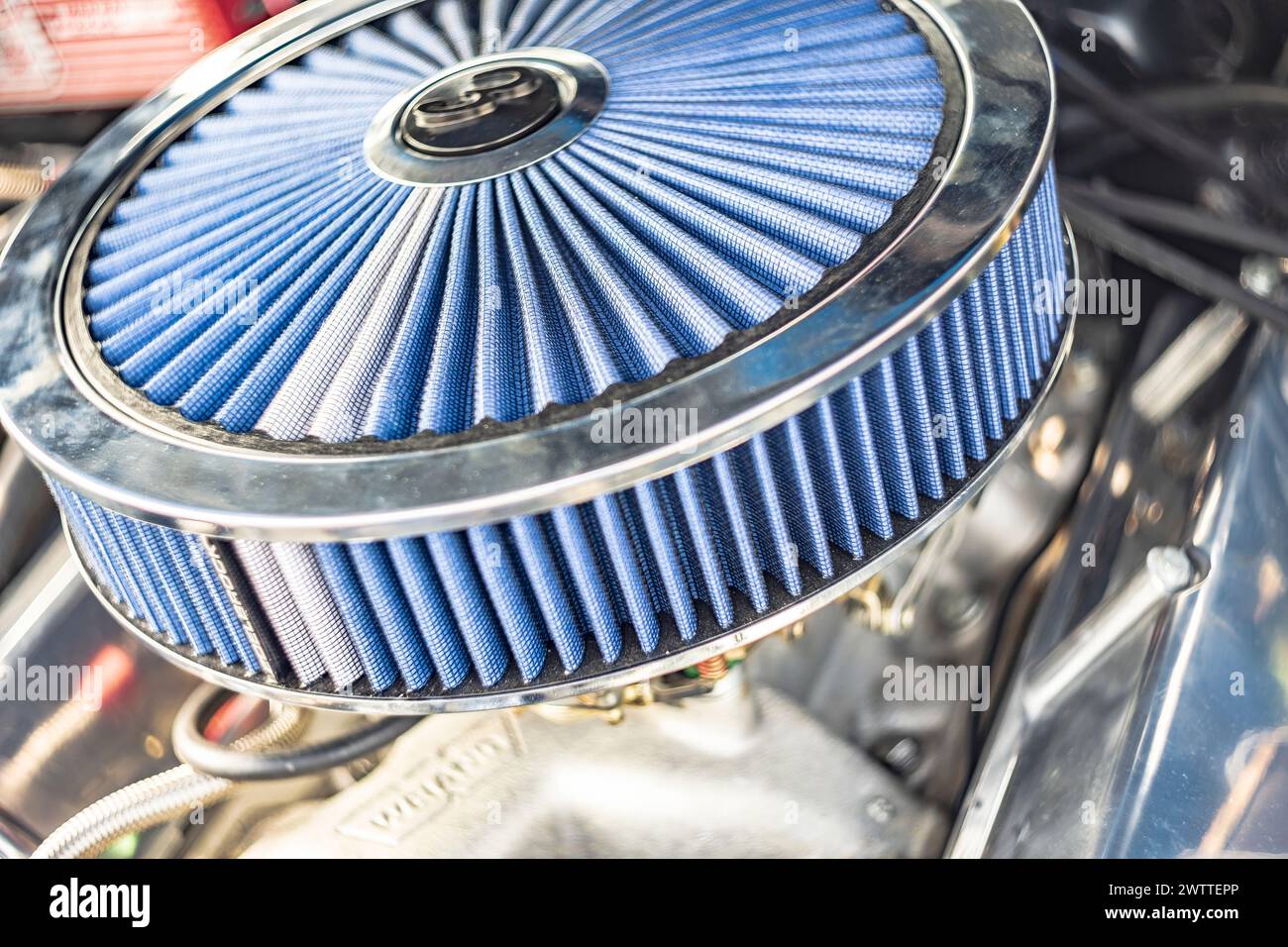 Vue détaillée d'un moteur de voiture américain vintage avec un filtre à air classique de style gâteau. Banque D'Images