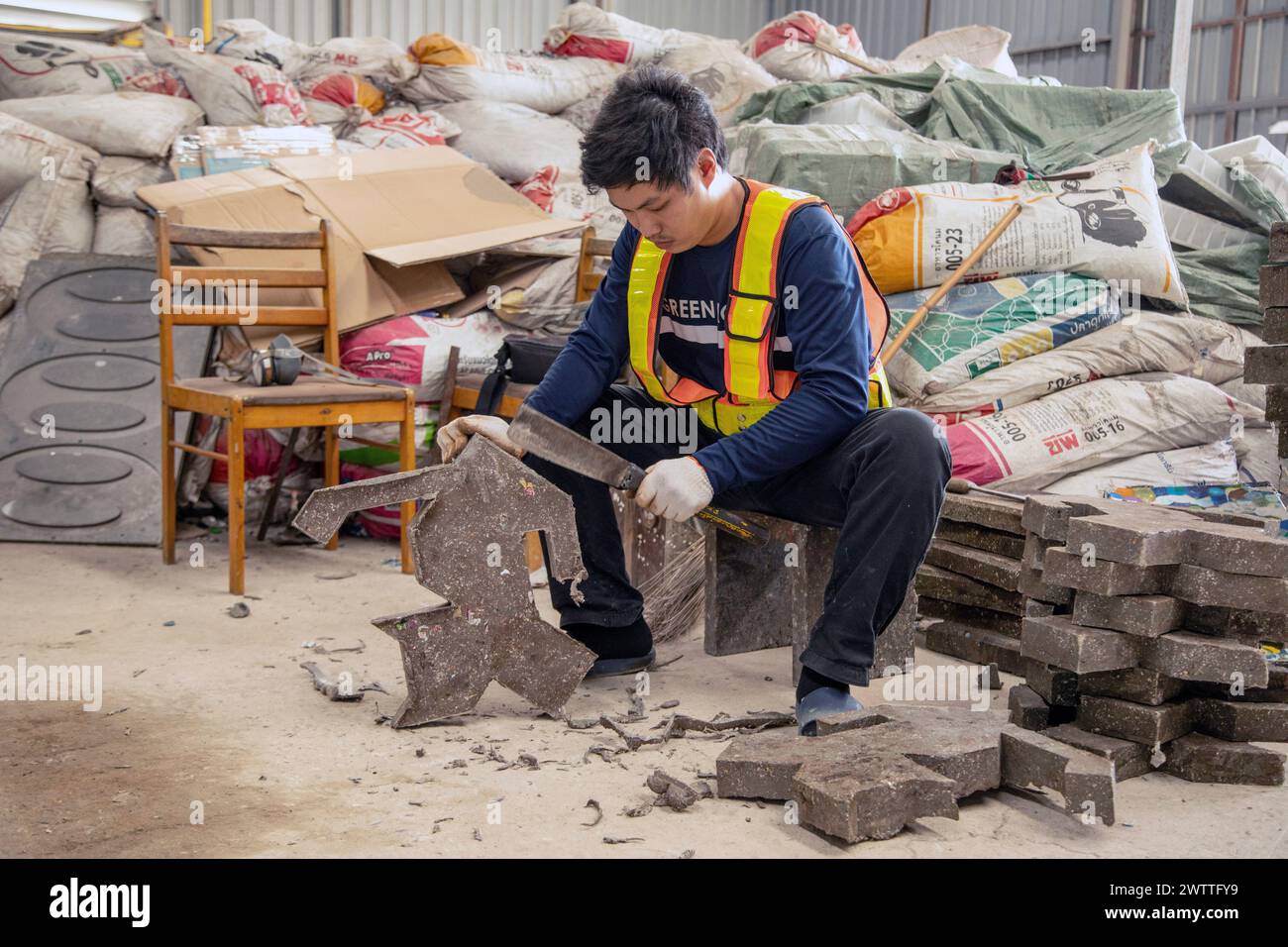 Travailleur triant des matériaux dans une installation de recyclage, Thaïlande Banque D'Images