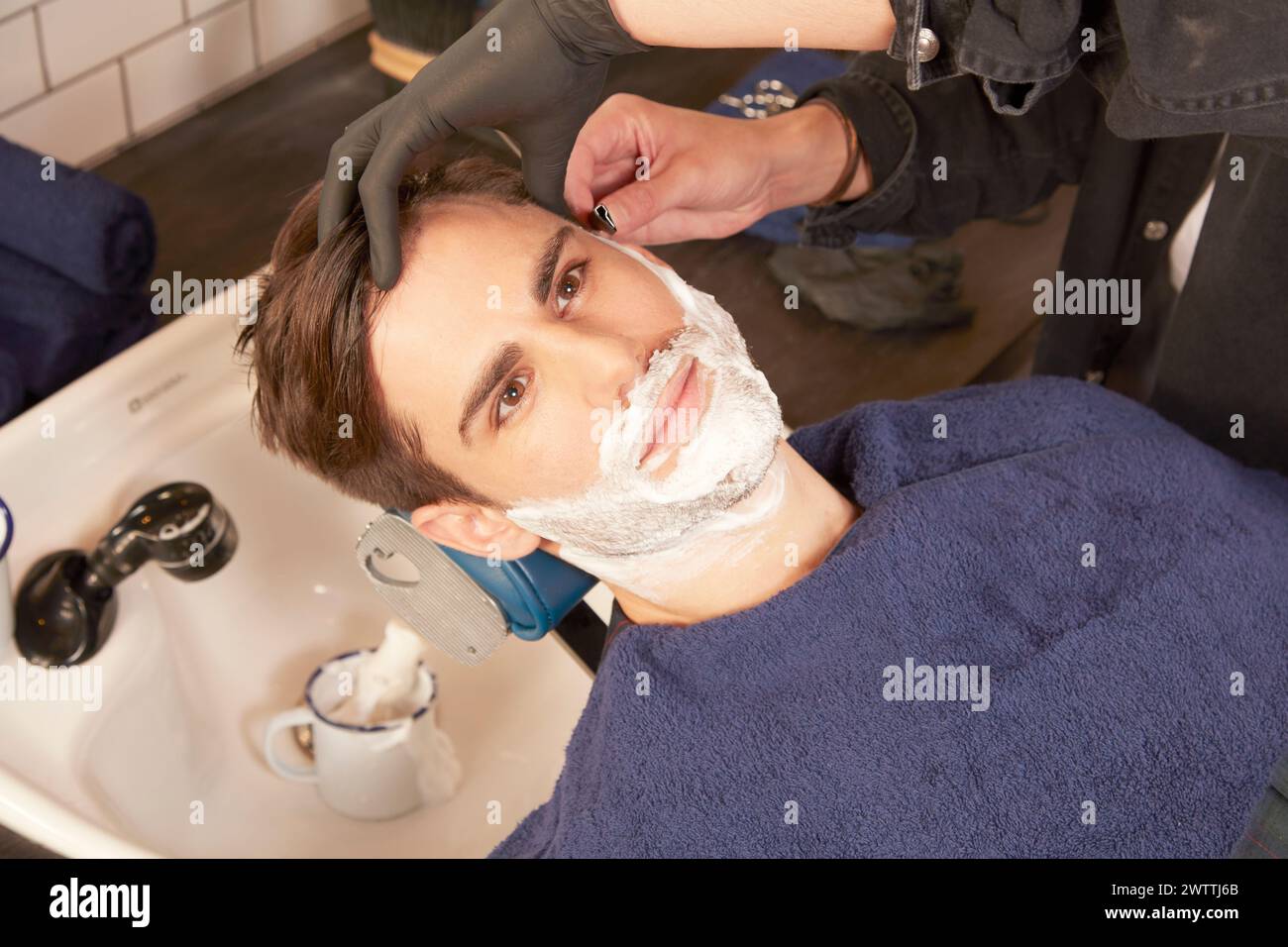 Homme se rasant dans un salon de coiffure Banque D'Images