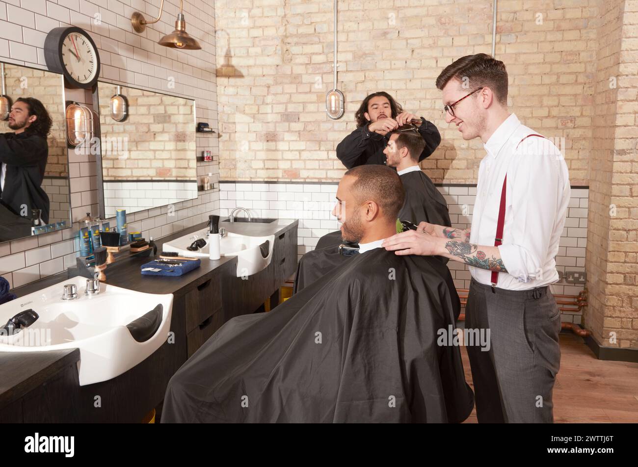 Coiffeur donnant une coupe de cheveux dans un salon Banque D'Images