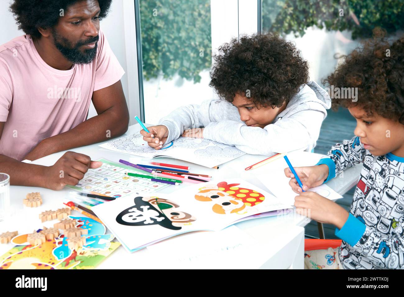 Famille coloriant ensemble à une table. Banque D'Images