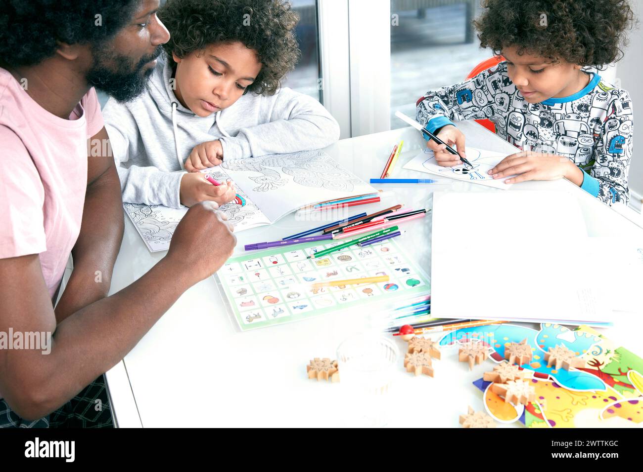 Famille coloriant ensemble à une table Banque D'Images