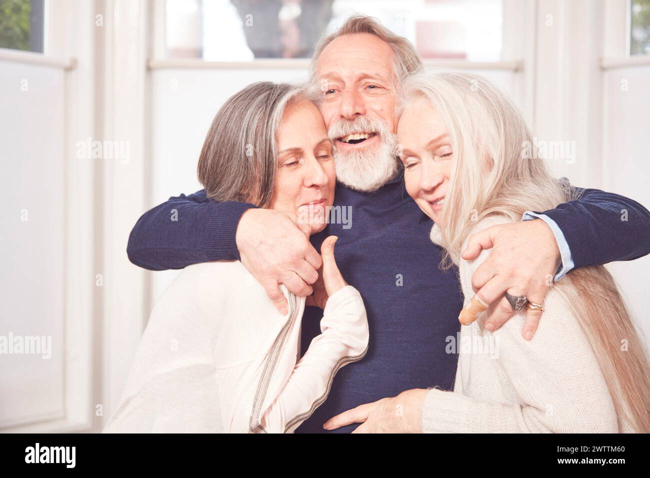 Trois adultes seniors heureux embrassant et souriant Banque D'Images