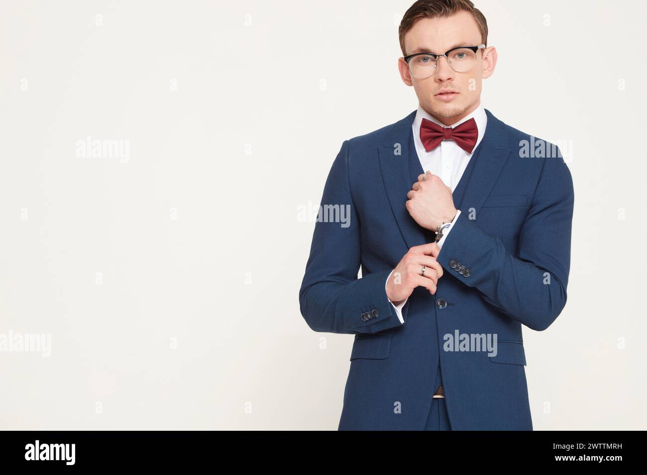 Homme en costume bleu avec noeud papillon rouge Banque D'Images