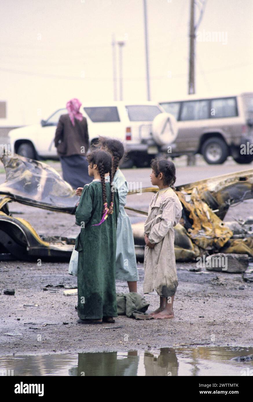 23 mars 1991 des enfants chiites irakiens se tiennent parmi les flaques d'eau dans un camp de réfugiés près de Safwan dans le sud de l'Irak, près de la frontière avec le Koweït. Banque D'Images