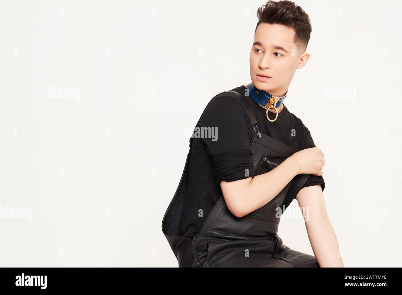 Individuel élégant dans une tenue noire avec un col bleu Banque D'Images