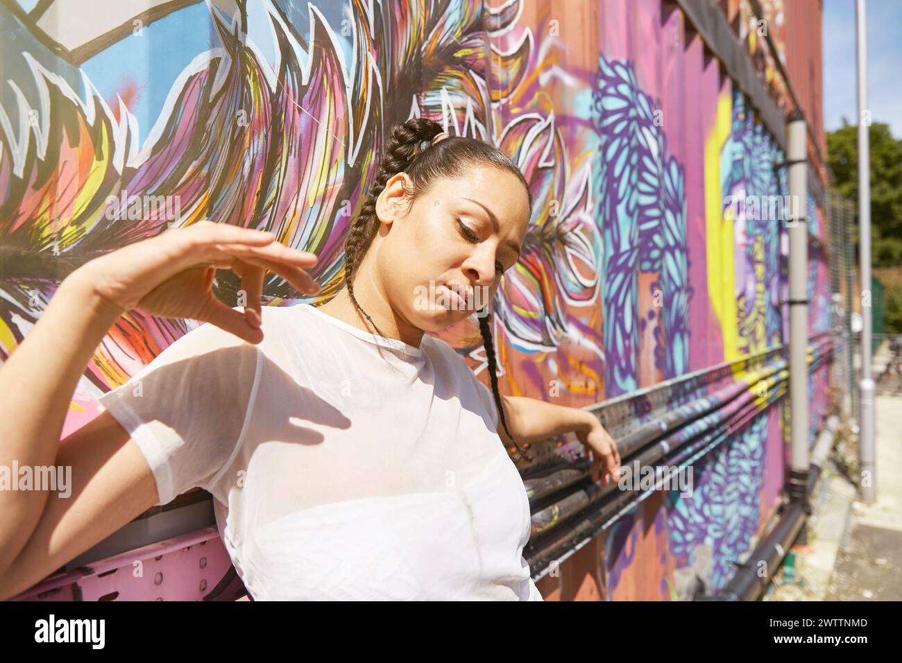 Woman posing in front of wall graffiti colorés Banque D'Images
