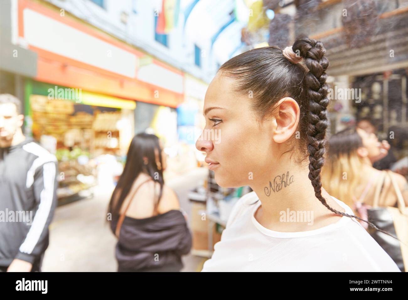 Femme aux cheveux tressés dans une rue animée Banque D'Images