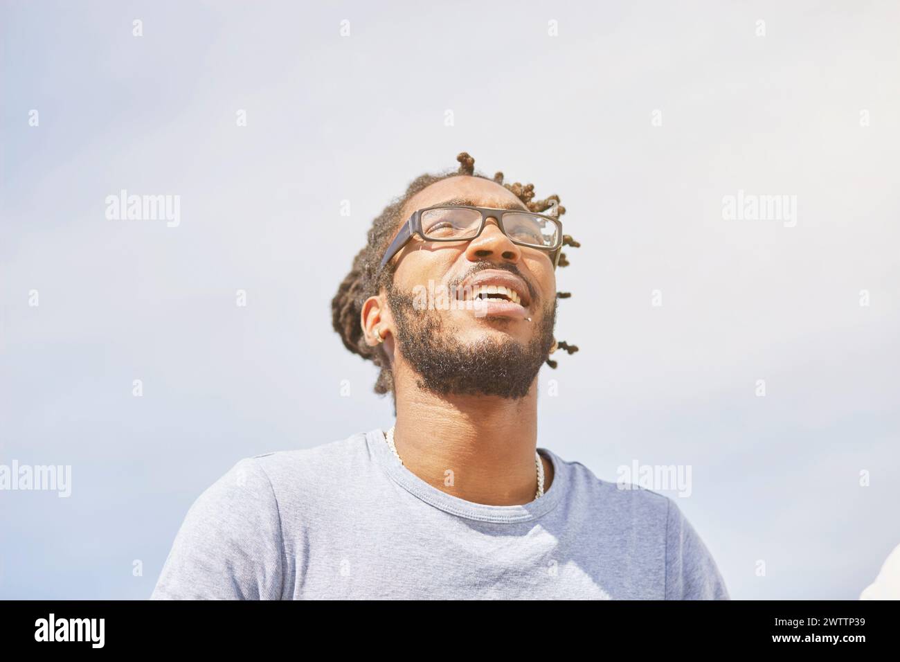 Homme souriant sur fond de ciel lumineux Banque D'Images