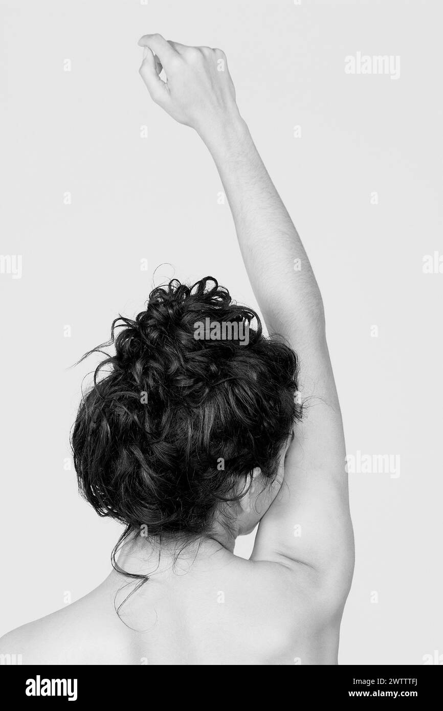 Photo en noir et blanc du dos d'une personne avec le bras levé Banque D'Images