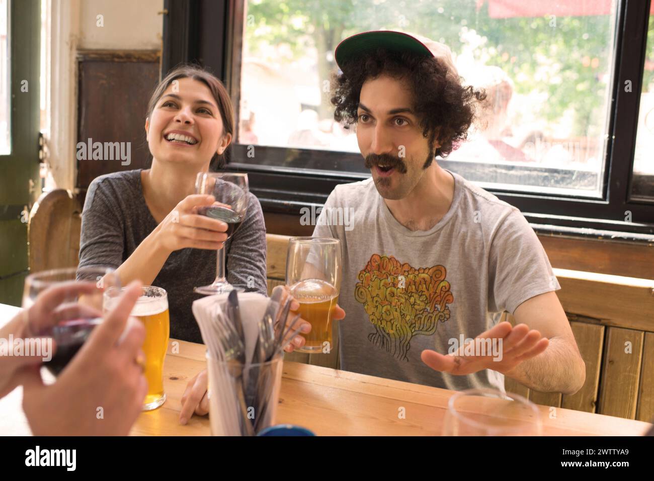 Amis riant et buvant dans un pub Banque D'Images