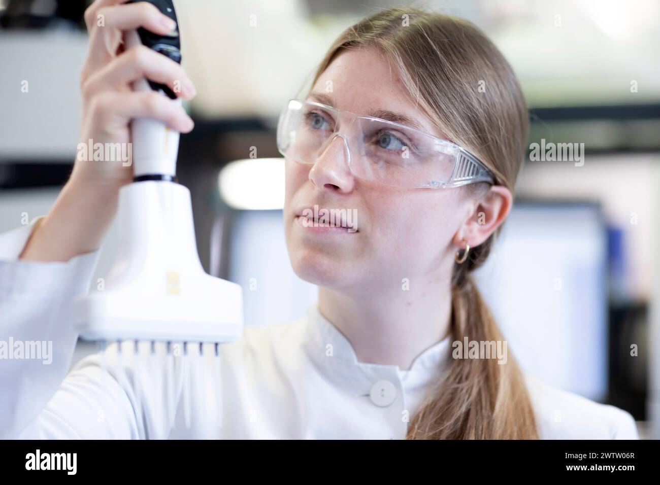 Scientifique ciblé ajustant l'équipement de laboratoire. Banque D'Images