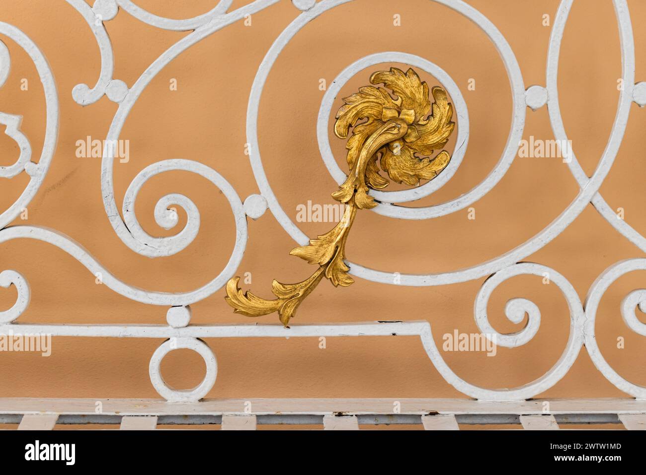 Balustrades forgées blanches vintage avec fleur d'or devant le mur jaune, photo en gros plan, vue de face Banque D'Images